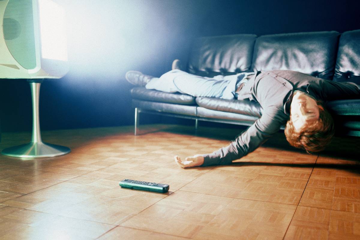 Man Lying on Sofa in Front of TV