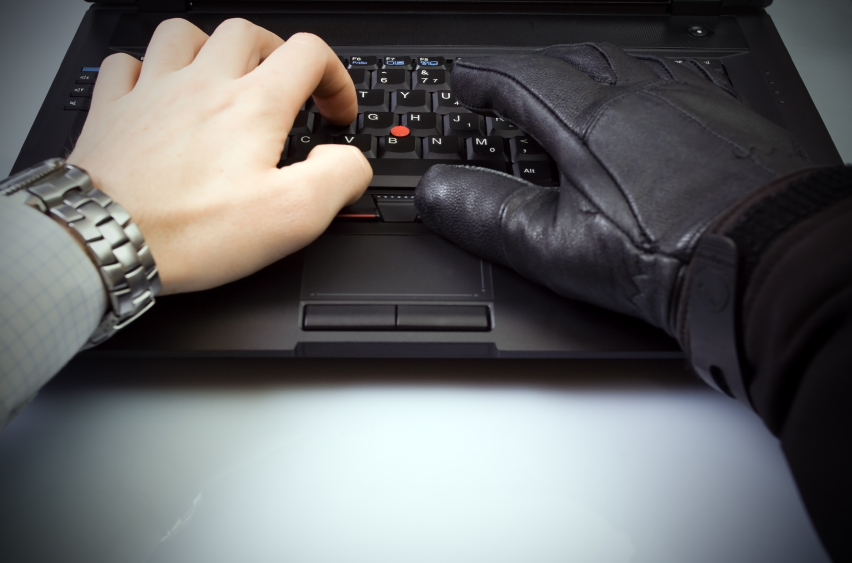 Businessman and hacker hands on laptop keyboard