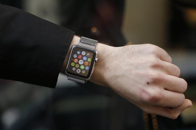 A customer presents his Apple Watch after buying it at a store in Paris